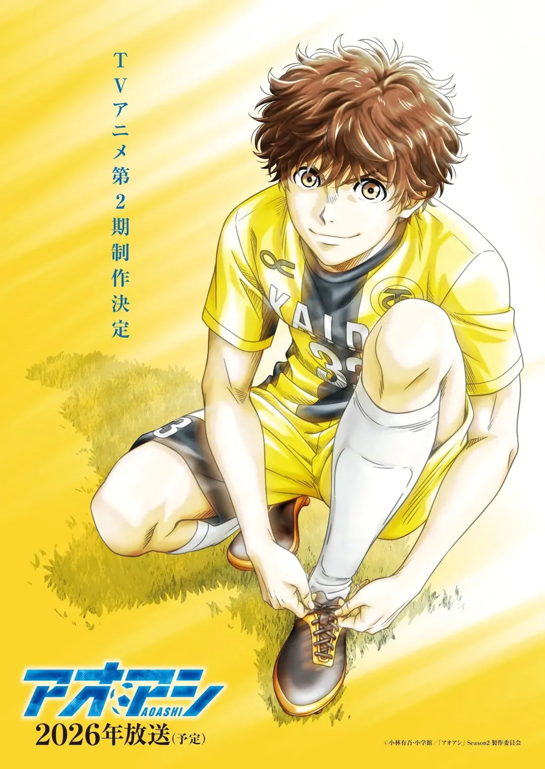 Promotional artwork for the second season of the anime series 'Ao Ashi,' depicting a young male soccer player kneeling on a sun-drenched field, tying his cleats. He has short, slightly tousled brown hair and a friendly expression. He's wearing a vibrant yellow soccer jersey with dark blue and black accents, black shorts, and white soccer socks. The jersey displays a logo and the number '33.' The style is reminiscent of modern anime, with clean lines and a focus on detailed character design. The background is a simple, yellow-toned field, suggesting a bright, sunny day.  In the upper left corner, Japanese text announces the second season's production and projected broadcast date of 2026. The show's title 'Ao Ashi' with a soccer ball logo is prominently displayed at the bottom. The overall image conveys excitement and anticipation for the upcoming season.